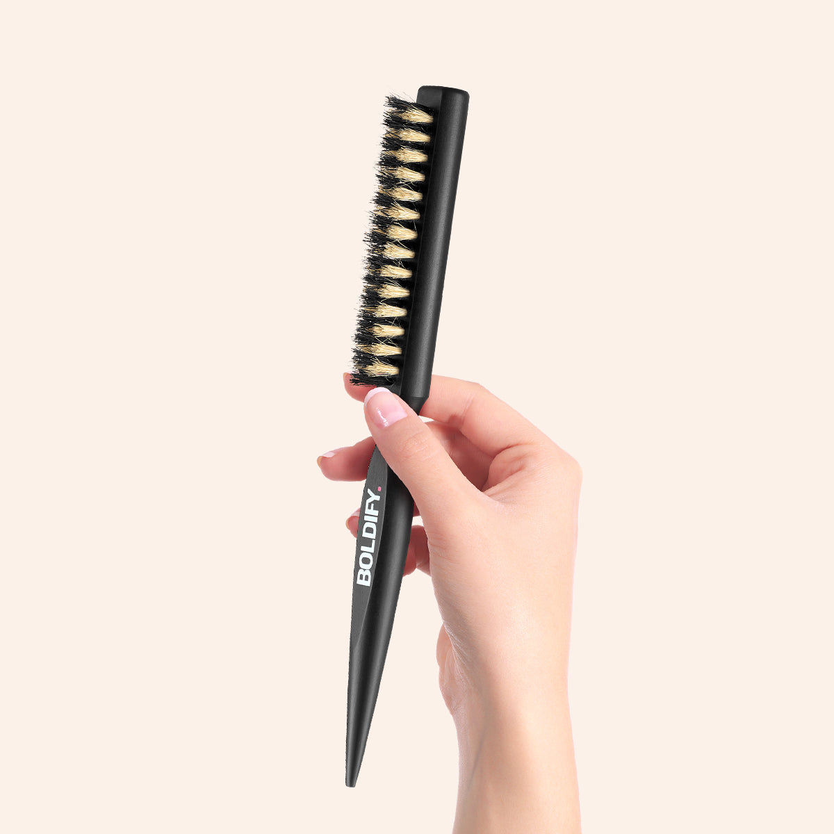 Holding a professional black teaser hairbrush BOLDIFY